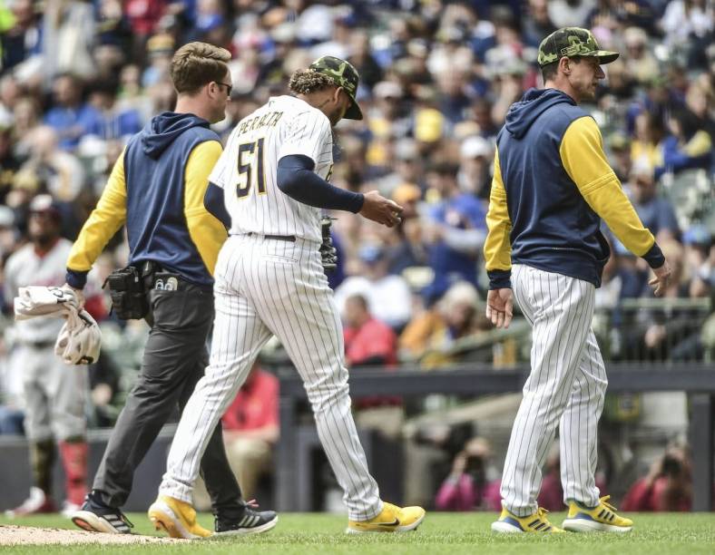 May 22, 2022; Milwaukee, Wisconsin, USA;  Milwaukee Brewers pitcher Freddy Peralta (51) leaves the game with manager Craig Counsell after experiencing right shoulder tightness in the fourth inning during game against the Washington Nationals at American Family Field. Mandatory Credit: Benny Sieu-USA TODAY Sports