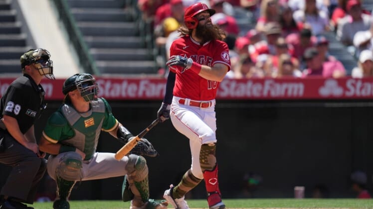 May 22, 2022; Anaheim, California, USA; Los Angeles Angels left fielder Brandon Marsh (16) follows through on a run-scoring single in the fifth inning as Oakland Athletics catcher Sean Murphy (12) and umpire Sean Barber (29) watch at Angel Stadium. Mandatory Credit: Kirby Lee-USA TODAY Sports
