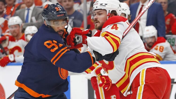 May 22, 2022; Edmonton, Alberta, CAN;Edmonton Oilers forward Evander Kane (91) battle for position with Calgary Flames defensemen Rasmus Andersson (4) during the first period in game three of the second round of the 2022 Stanley Cup Playoffs at Rogers Place. Mandatory Credit: Perry Nelson-USA TODAY Sports