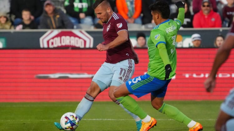 May 22, 2022; Commerce City, Colorado, USA; Colorado Rapids forward Diego Rubio (11) kicks the ball past Seattle Sounders defender Xavier Arreaga (3) in the second half at Dick's Sporting Goods Park. Mandatory Credit: Ron Chenoy-USA TODAY Sports