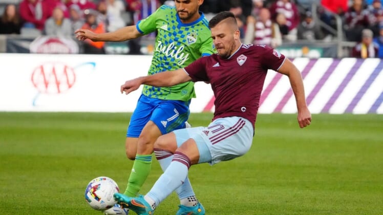 May 22, 2022; Commerce City, Colorado, USA; Colorado Rapids forward Diego Rubio (11) kicks the ball past Seattle Sounders midfielder Cristian Roldan (7) in the second half at Dick's Sporting Goods Park. Mandatory Credit: Ron Chenoy-USA TODAY Sports