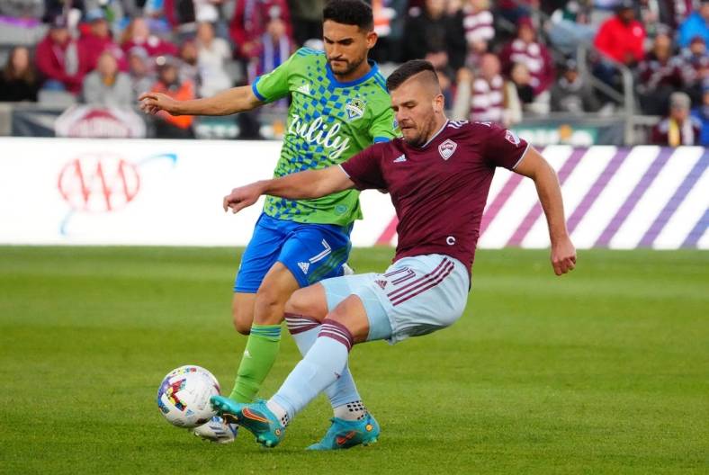 May 22, 2022; Commerce City, Colorado, USA; Colorado Rapids forward Diego Rubio (11) kicks the ball past Seattle Sounders midfielder Cristian Roldan (7) in the second half at Dick's Sporting Goods Park. Mandatory Credit: Ron Chenoy-USA TODAY Sports