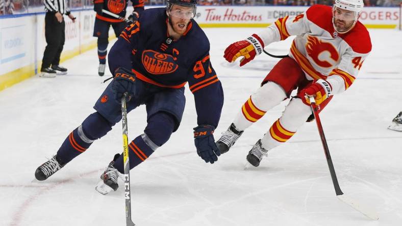 May 22, 2022; Edmonton, Alberta, CAN;Edmonton Oilers forward Connor McDavid (97) carries the puck around Calgary Flames defensemen Erik Gudbranson (44) during the third period  in game three of the second round of the 2022 Stanley Cup Playoffs at Rogers Place. Mandatory Credit: Perry Nelson-USA TODAY Sports