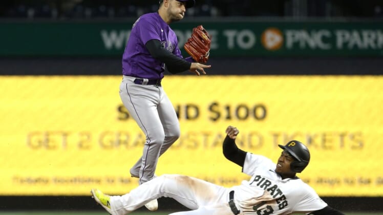 May 23, 2022; Pittsburgh, Pennsylvania, USA;  Colorado Rockies shortstop Jose Iglesias (11) turns a double play over Pittsburgh Pirates third baseman Ke'Bryan Hayes (13) to end the fifth inning at PNC Park. Mandatory Credit: Charles LeClaire-USA TODAY Sports