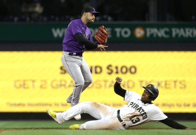May 23, 2022; Pittsburgh, Pennsylvania, USA;  Colorado Rockies shortstop Jose Iglesias (11) turns a double play over Pittsburgh Pirates third baseman Ke'Bryan Hayes (13) to end the fifth inning at PNC Park. Mandatory Credit: Charles LeClaire-USA TODAY Sports