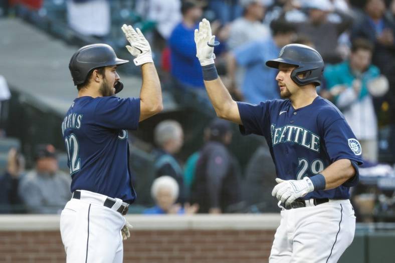 May 23, 2022; Seattle, Washington, USA; Seattle Mariners catcher Cal Raleigh (29) exchanges a high five with designated hitter Luis Torrens (22) after hitting a two-run home run against the Oakland Athletics during the fourth inning at T-Mobile Park. Mandatory Credit: Joe Nicholson-USA TODAY Sports