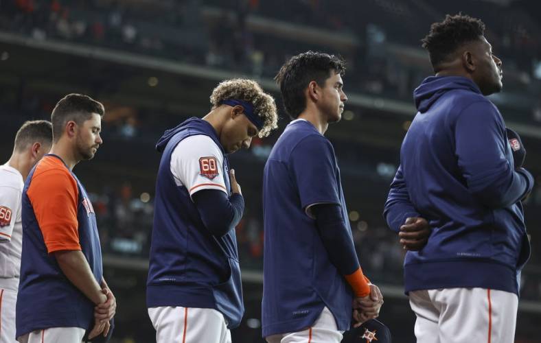 May 24, 2022; Houston, Texas, USA; Houston Astros players stand in a moment of silence for the victims of the school shooting in Uvalde, Texas before the game against the Cleveland Guardians at Minute Maid Park. Mandatory Credit: Troy Taormina-USA TODAY Sports