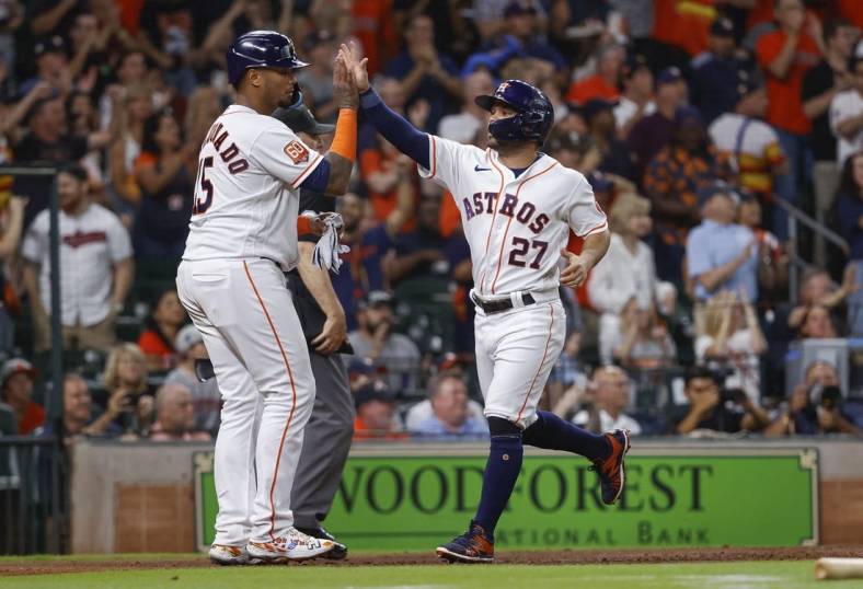 May 24, 2022; Houston, Texas, USA; Houston Astros second baseman Jose Altuve (27) celebrates with catcher Martin Maldonado (15) after scoring a run during the third inning against the Cleveland Guardians at Minute Maid Park. Mandatory Credit: Troy Taormina-USA TODAY Sports