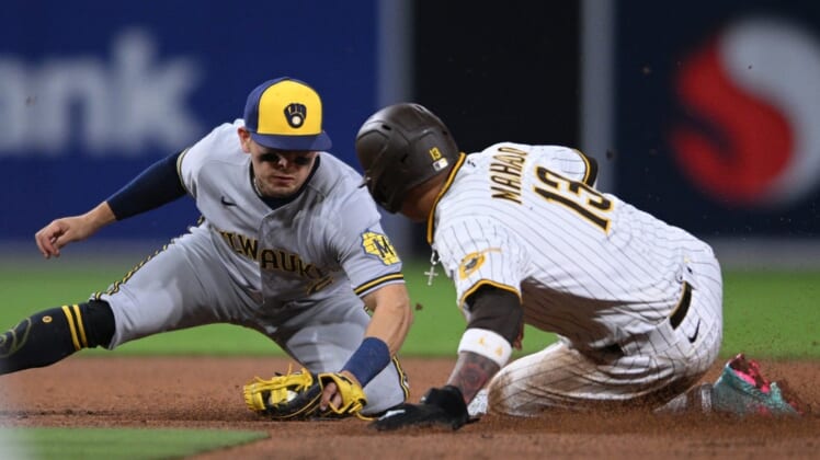 May 24, 2022; San Diego, California, USA; San Diego Padres third baseman Manny Machado (13) is tagged out by Milwaukee Brewers shortstop Luis Urias (2) attempting to steal second base during the fifth inning at Petco Park. Mandatory Credit: Orlando Ramirez-USA TODAY Sports