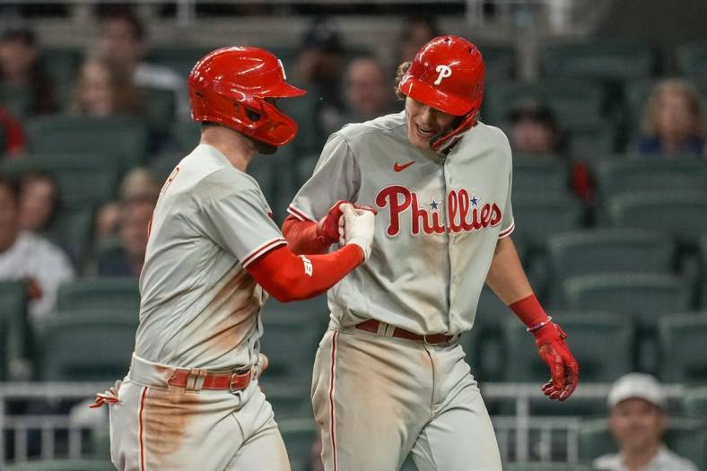 May 24, 2022; Cumberland, Georgia, USA; Philadelphia Phillies designated hitter Bryce Harper (3) (left) reacts with third baseman Alec Bohm (28) after hitting a two run home run against the Atlanta Braves during the ninth inning at Truist Park. Mandatory Credit: Dale Zanine-USA TODAY Sports