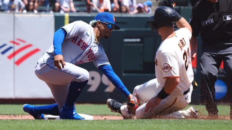 May 25, 2022; San Francisco, California, USA;  New York Mets shortstop Francisco Lindor (12) catches San Francisco Giants catcher Joey Bart (21) trying to steal second base during the first inning at Oracle Park. Mandatory Credit: Kelley L Cox-USA TODAY Sports