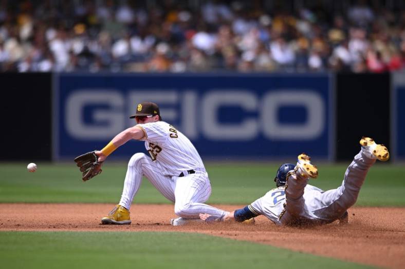 May 25, 2022; San Diego, California, USA; Milwaukee Brewers left fielder Christian Yelich (right) steals second base ahead of the throw to San Diego Padres second baseman Jake Cronenworth (left) during the fourth inning at Petco Park. Mandatory Credit: Orlando Ramirez-USA TODAY Sports