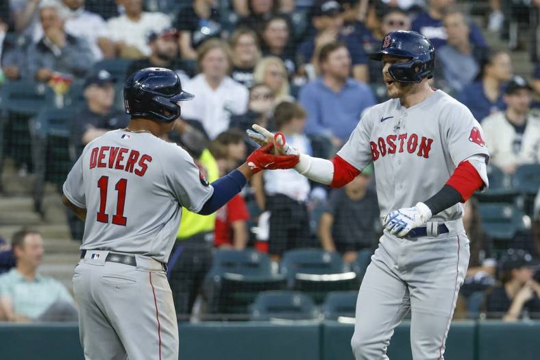 May 26, 2022; Chicago, Illinois, USA; Boston Red Sox second baseman Trevor Story (10) celebrates with third baseman Rafael Devers (11) after hitting a three-run home run against the Chicago White Sox during the second inning at Guaranteed Rate Field. Mandatory Credit: Kamil Krzaczynski-USA TODAY Sports