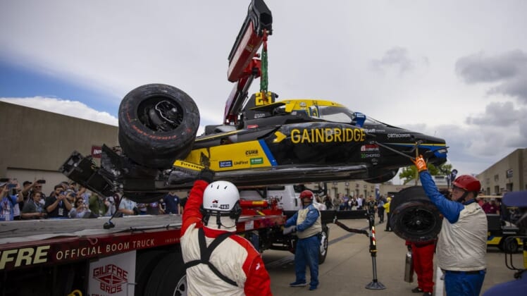 May 27, 2022; Indianapolis, Indiana, USA; The crashed car of IndyCar Series driver Colton Herta is unloaded by a tow truck in the garage area after crashing during Carb Day practice at Indianapolis Motor Speedway. Mandatory Credit: Mark J. Rebilas-USA TODAY Sports