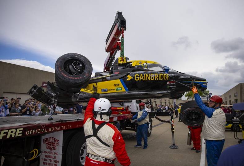 May 27, 2022; Indianapolis, Indiana, USA; The crashed car of IndyCar Series driver Colton Herta is unloaded by a tow truck in the garage area after crashing during Carb Day practice at Indianapolis Motor Speedway. Mandatory Credit: Mark J. Rebilas-USA TODAY Sports