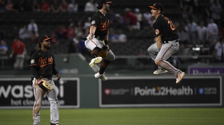 May 27, 2022; Boston, Massachusetts, USA;  Baltimore Orioles center fielder Ryan McKenna (26) and right fielder Trey Mancini (16) react while center fielder Cedric Mullins (31) looks on after the Orioles defeated the Boston Red Sox at Fenway Park. Mandatory Credit: Bob DeChiara-USA TODAY Sports