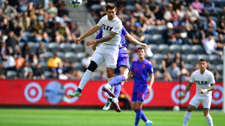 May 28, 2022; Los Angeles, California, USA; Los Angeles FC midfielder Ryan Hollingshead (24) plays for the ball against San Jose Earthquakes midfielder Jan Gregus (17)  during the first half at Banc of California Stadium. Mandatory Credit: Gary A. Vasquez-USA TODAY Sports