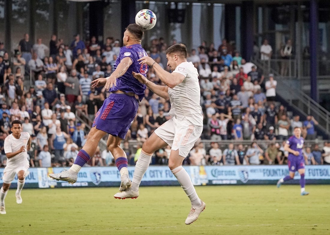 May 28, 2022; Kansas City, Kansas, USA; Vancouver Whitecaps forward Lucas Cavallini (9) heads the ball as Sporting Kansas City defender Andreu Fontas (3) defends during the first half at Children's Mercy Park. Mandatory Credit: Denny Medley-USA TODAY Sports