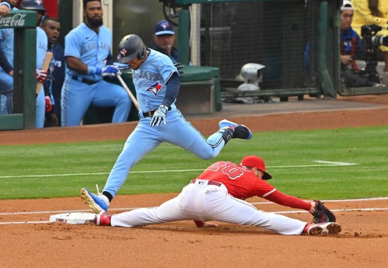 May 28, 2022; Anaheim, California, USA;  Toronto Blue Jays second baseman Santiago Espinal (5) is out as Los Angeles Angels first baseman Jared Walsh (20) stretches for the ball in the first inning of the game at Angel Stadium. Mandatory Credit: Jayne Kamin-Oncea-USA TODAY Sports