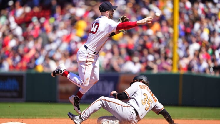 May 29, 2022; Boston, Massachusetts, USA; Boston Red Sox second baseman Trevor Story (10) turns a double play with Baltimore Orioles designated hitter Adley Rutschman (35) sliding into second base during the fourth inning at Fenway Park. Mandatory Credit: Gregory Fisher-USA TODAY Sports