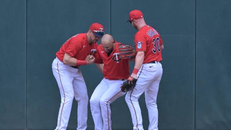 May 29, 2022; Minneapolis, Minnesota, USA; Minnesota Twins left fielder Trevor Larnach (13) and right fielder Kyle Garlick (30) help center fielder Royce Lewis (23) off the ground after Lewis made a catch against the Kansas City Royals during the third inning at Target Field. Lewis would leave the game the following inning. Mandatory Credit: Jeffrey Becker-USA TODAY Sports