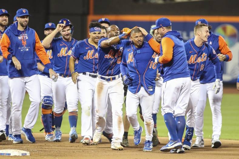 May 29, 2022; New York City, New York, USA;  New York Mets third baseman Eduardo Escobar (10) celebrates with his teammates after hitting a game winning RBI double to beat the Philadelphia Phillies 5-4 in ten innings at Citi Field. Mandatory Credit: Wendell Cruz-USA TODAY Sports