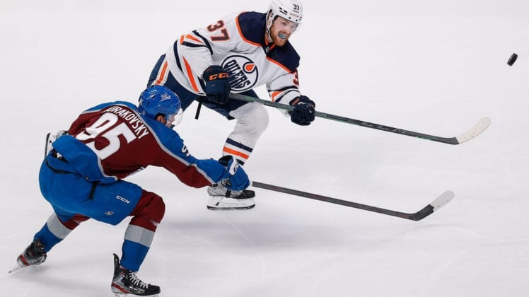 May 31, 2022; Denver, Colorado, USA; Edmonton Oilers left wing Warren Foegele (37) clears the puck away from Colorado Avalanche left wing Andre Burakovsky (95) in the first period in game one of the Western Conference Final of the 2022 Stanley Cup Playoffs at Ball Arena. Mandatory Credit: Isaiah J. Downing-USA TODAY Sports