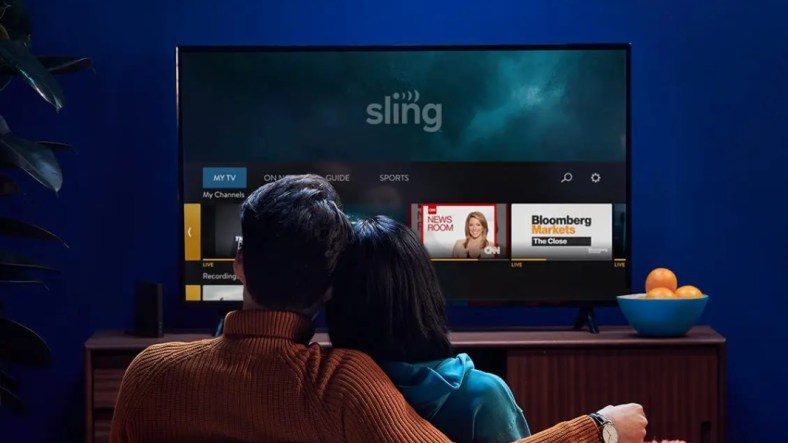 couple sitting on couch streaming Sling TV
