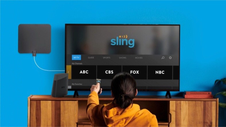 two people sitting on a couch watching Sling TV