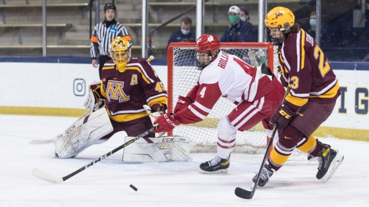 March 16, 2021; South Bend, IN, USA; Minnesota Golden Gophers goaltender Jack LaFontaine (45) makes a save as Wisconsin Badgers forward Dylan Holloway (4) looks for a rebound during the Big Ten hockey tournament championship game at Compton Family Ice Arena. Mandatory Credit: John Mersits/South Bend Tribune via USA TODAY NETWORK