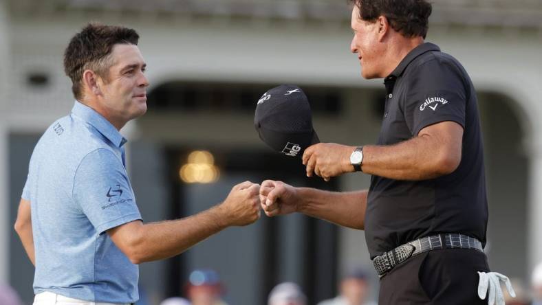 May 22, 2021; Kiawah Island, South Carolina, USA; Louis Oosthuizen (L) and Phil Mickelson (R) share a fist bump after completing their round during the third round of the PGA Championship golf tournament. Mandatory Credit: Geoff Burke-USA TODAY Sports