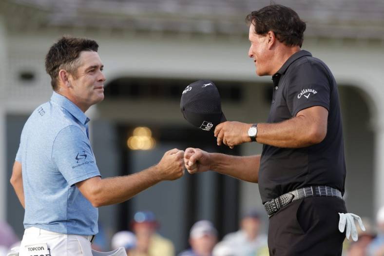 May 22, 2021; Kiawah Island, South Carolina, USA; Louis Oosthuizen (L) and Phil Mickelson (R) share a fist bump after completing their round during the third round of the PGA Championship golf tournament. Mandatory Credit: Geoff Burke-USA TODAY Sports