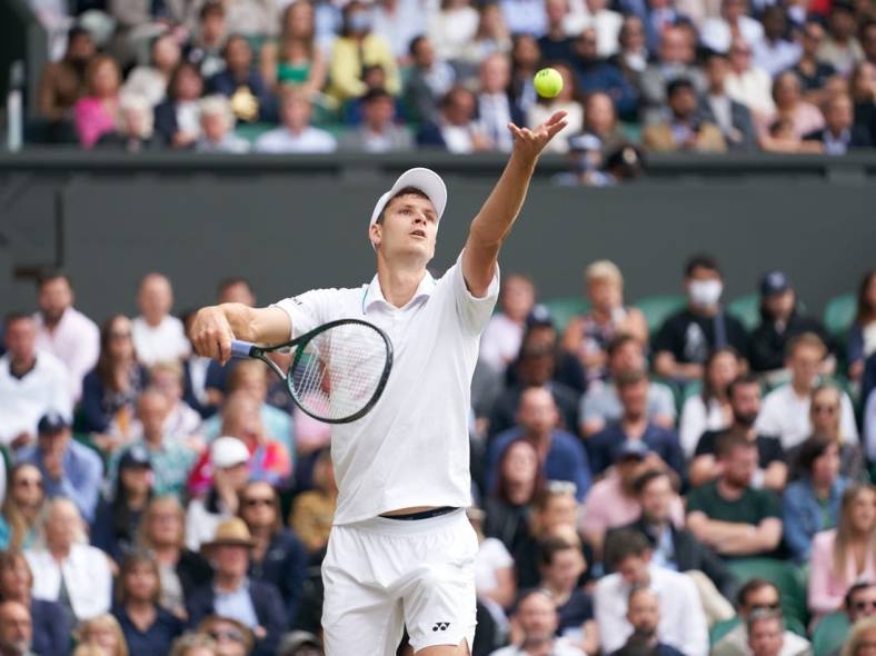 Jul 7, 2021; London, United Kingdom; Hubert Hurkacz (POL) seen in service action against Roger Federer (SUI) in the quarter finals at All England Lawn Tennis and Croquet Club. Mandatory Credit: Peter van den Berg-USA TODAY Sports