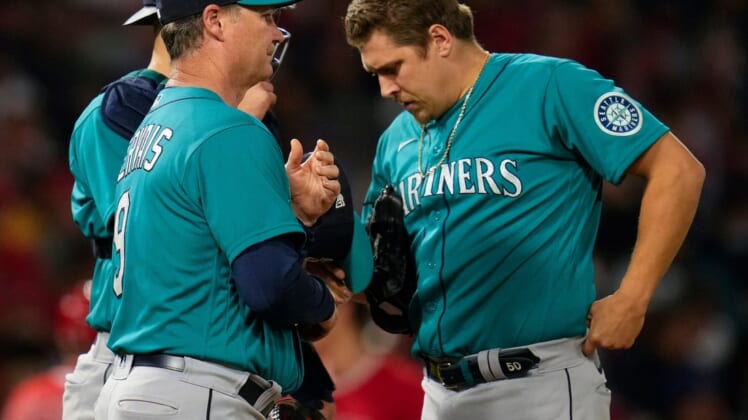 Sep 25, 2021; Anaheim, California, USA; Seattle Mariners manager Scott Servais (9) talks to relief pitcher Erik Swanson (50) during in the fifth inning against the Los Angeles Angels at Angel Stadium. Mandatory Credit: Robert Hanashiro-USA TODAY Sports