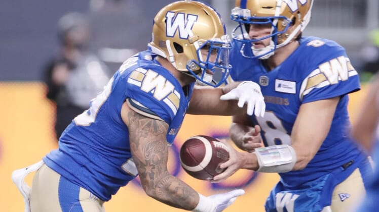Nov 6, 2021; Winnipeg, Manitoba, CAN; Winnipeg Blue Bombers quarterback Zach Collaros (8) hands the ball off to Winnipeg Blue Bombers running back Brady Oliveira (20) against the Montreal Alouettes during the 2nd quarter during a Canadian football League game at IG Field. Mandatory Credit: Bruce Fedyck-USA TODAY Sports