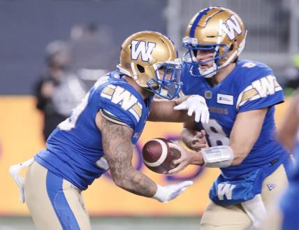 Nov 6, 2021; Winnipeg, Manitoba, CAN; Winnipeg Blue Bombers quarterback Zach Collaros (8) hands the ball off to Winnipeg Blue Bombers running back Brady Oliveira (20) against the Montreal Alouettes during the 2nd quarter during a Canadian football League game at IG Field. Mandatory Credit: Bruce Fedyck-USA TODAY Sports