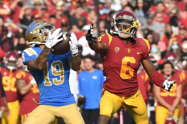 Nov 20, 2021; Los Angeles, California, USA;  UCLA Bruins running back Kazmeir Allen (19) catches a touchdown pass against Southern California Trojans cornerback Isaac Taylor-Stuart (6) in the first half at the Los Angeles Memorial Coliseum. Mandatory Credit: Richard Mackson-USA TODAY Sports
