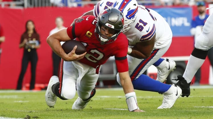 Dec 12, 2021; Tampa, Florida, USA; Tampa Bay Buccaneers quarterback Tom Brady (12) runs with the ball as Buffalo Bills defensive end Bryan Cox (51) defends during the first half at Raymond James Stadium. Mandatory Credit: Kim Klement-USA TODAY Sports