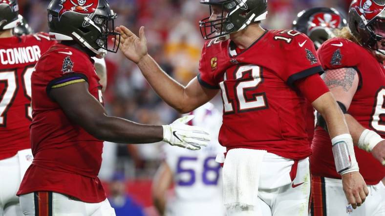 Dec 12, 2021; Tampa, Florida, USA; Tampa Bay Buccaneers quarterback Tom Brady (12) celebrates with  running back Leonard Fournette (7) after running the ball in for a touchdown against the Buffalo Bills during the first half at Raymond James Stadium. Mandatory Credit: Kim Klement-USA TODAY Sports