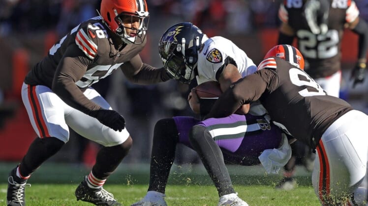Ravens quarterback Lamar Jackson is brought down by Browns defensive end Myles Garrett (right) during the first half Sunday, Dec. 12, 2021, in Cleveland.Browns 14