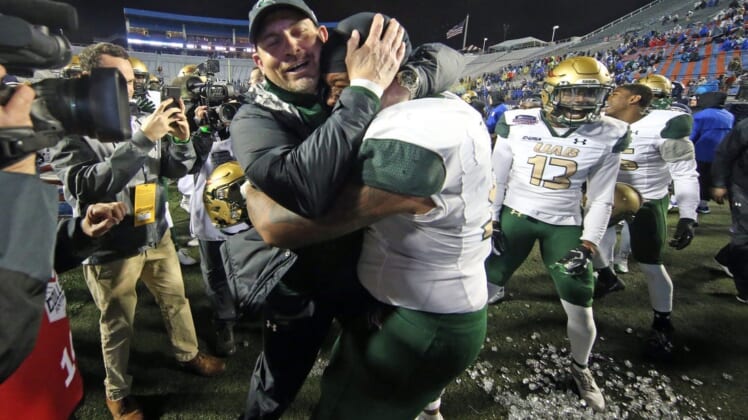 Dec 18, 2021; Shreveport, LA, USA; UAB Blazers head coach Bill Clark embraces  UAB Blazers offensive linemen Colby Ragland (53) after defeating the BYU Cougars during the 2021 Independence Bowl at Independence Stadium. Mandatory Credit: Petre Thomas-USA TODAY Sports