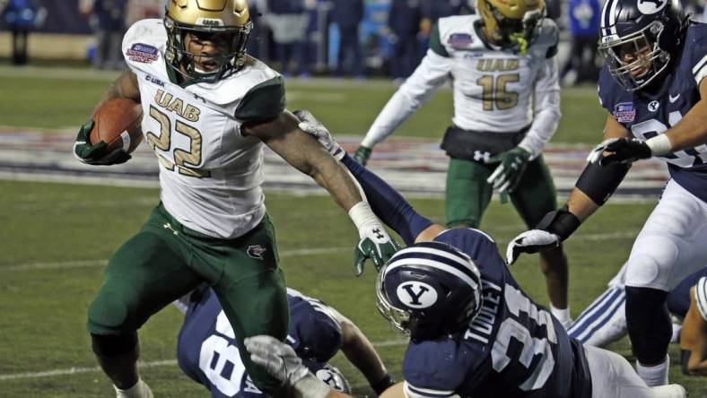 Dec 18, 2021; Shreveport, LA, USA; UAB Blazers running back DeWayne McBride (22) breaks a tackle against the BYU Cougars linebacker Max Tooley (31) during the fourth quarter during the 2021 Independence Bowl at Independence Stadium. Mandatory Credit: Petre Thomas-USA TODAY Sports