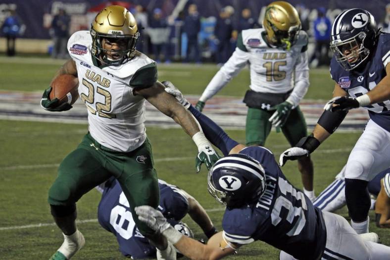 Dec 18, 2021; Shreveport, LA, USA; UAB Blazers running back DeWayne McBride (22) breaks a tackle against the BYU Cougars linebacker Max Tooley (31) during the fourth quarter during the 2021 Independence Bowl at Independence Stadium. Mandatory Credit: Petre Thomas-USA TODAY Sports