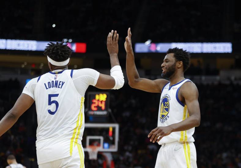 Jan 31, 2022; Houston, Texas, USA; Golden State Warriors center Kevon Looney (5) celebrates with forward Andrew Wiggins (22) after a play during the fourth quarter against the Houston Rockets at Toyota Center. Mandatory Credit: Troy Taormina-USA TODAY Sports