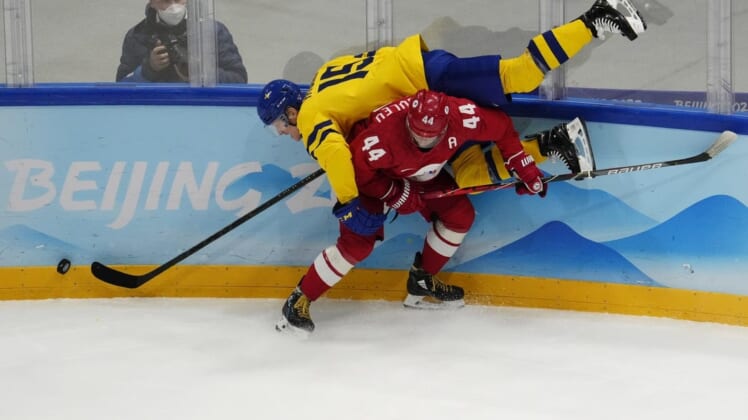Feb 18, 2022; Beijing, China; Team ROC defender Yegor Yakovlev (44) flips Team Sweden forward Gustav Rydahl (15) while battling for the puck in the third period during the Beijing 2022 Olympic Winter Games at National Indoor Stadium. Mandatory Credit: George Walker IV-USA TODAY Sports