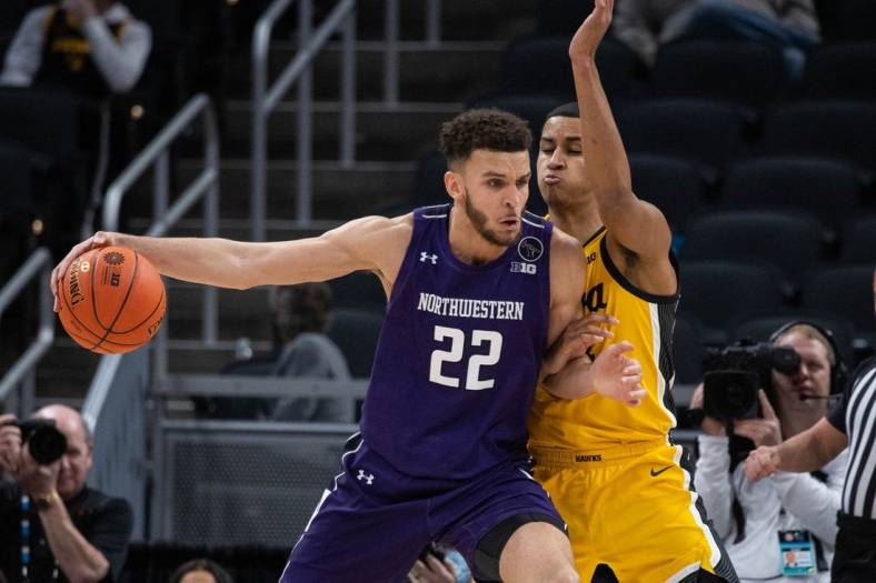 Mar 10, 2022; Indianapolis, IN, USA; Northwestern Wildcats forward Pete Nance (22) dribbles the ball while Iowa Hawkeyes forward Keegan Murray (15) defends in the first half at Gainbridge Fieldhouse. Mandatory Credit: Trevor Ruszkowski-USA TODAY Sports