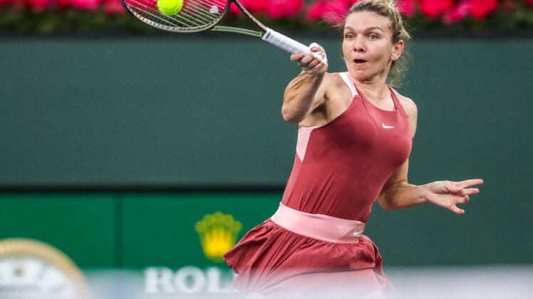 Simona Halep of Romania returns to Iga Swiatek of Poland during the WTA semifinals at the BNP Paribas Open at the Indian Wells Tennis Garden in Indian Wells, Calif., Friday, March 18, 2022.