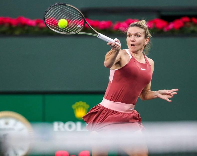 Simona Halep of Romania returns to Iga Swiatek of Poland during the WTA semifinals at the BNP Paribas Open at the Indian Wells Tennis Garden in Indian Wells, Calif., Friday, March 18, 2022.