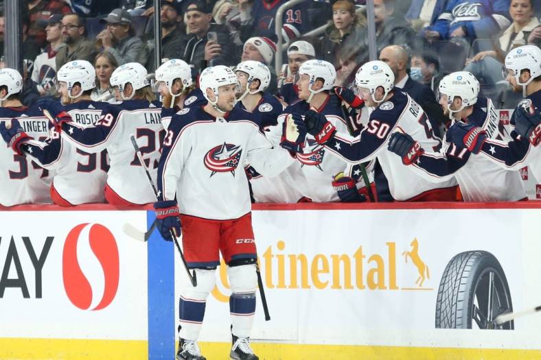 Mar 25, 2022; Winnipeg, Manitoba, CAN;  Columbus Blue Jackets forward Brendan Gaunce (23) is congratulated by his team mates on his goal against the Winnipeg Jets during the second period at Canada Life Centre. Mandatory Credit: Terrence Lee-USA TODAY Sports