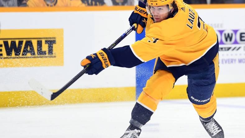 Mar 27, 2022; Nashville, Tennessee, USA; Nashville Predators defenseman Jeremy Lauzon (3) shoots during the third period against the Philadelphia Flyers at Bridgestone Arena. Mandatory Credit: Christopher Hanewinckel-USA TODAY Sports